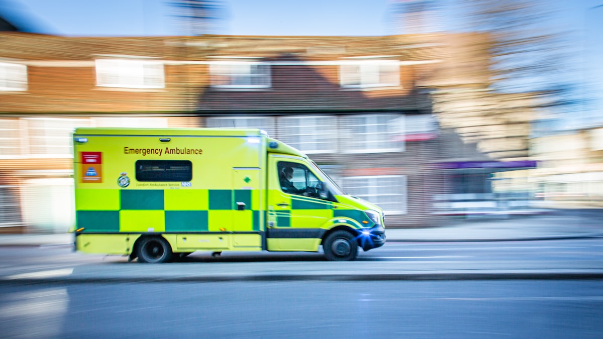 Emergency ambulance responding through a street, motion blurred